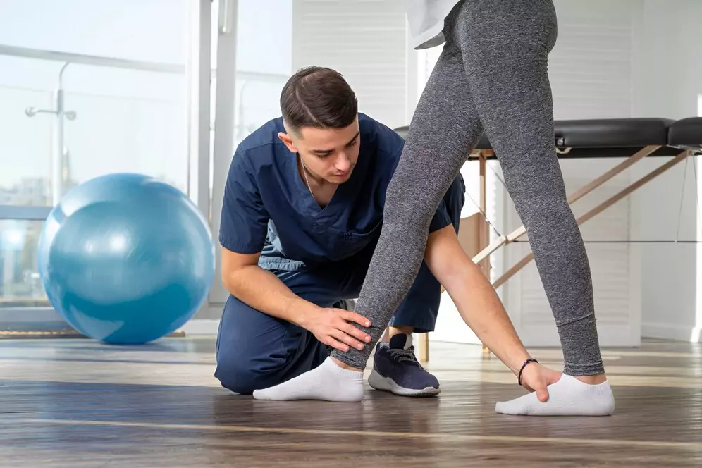 Fisioterapeuta auxiliando um paciente em exercícios de reabilitação, representando os cuidados especializados em Fisioterapia na Clínica Life Center.